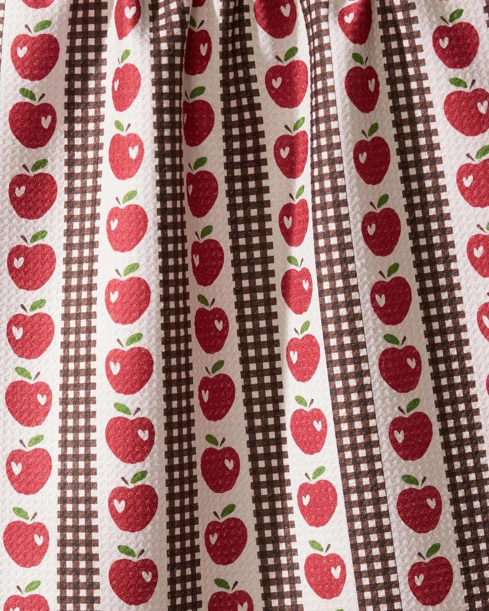 Fabric with red apple pattern on a brown and white striped background