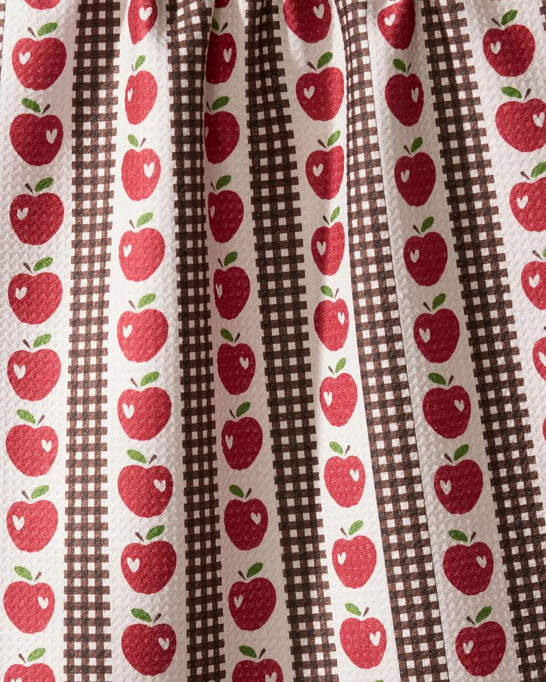 Fabric with red apple pattern on a brown and white striped background