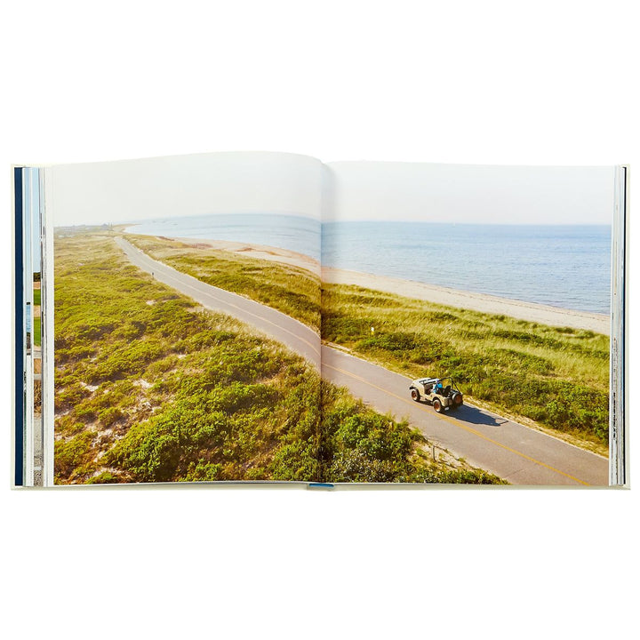 Open book showing a scenic road with a vehicle on a grassy landscape.