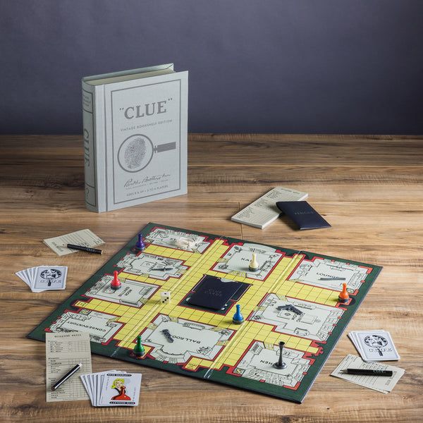Clue board game on a wooden table with game pieces and cards.