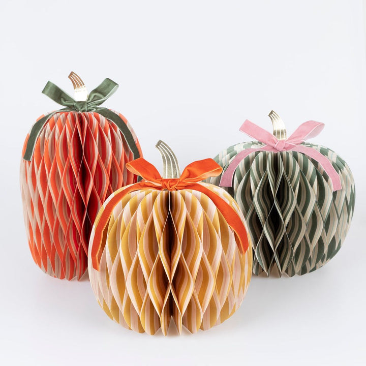 Three decorative paper pumpkins with ribbons on a white background