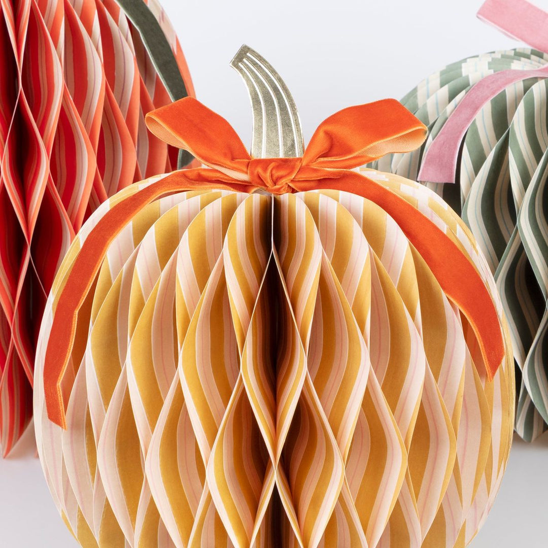 Decorative paper pumpkin with a bow on a white background