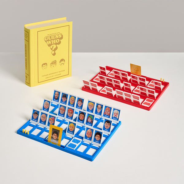 Guess Who? board game with cards and a yellow book on a gray background