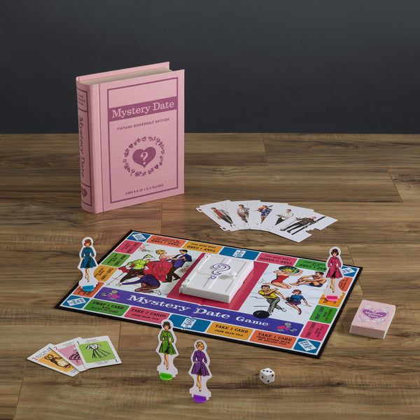 Mystery Date board game set on a wooden table with pink book and cards.