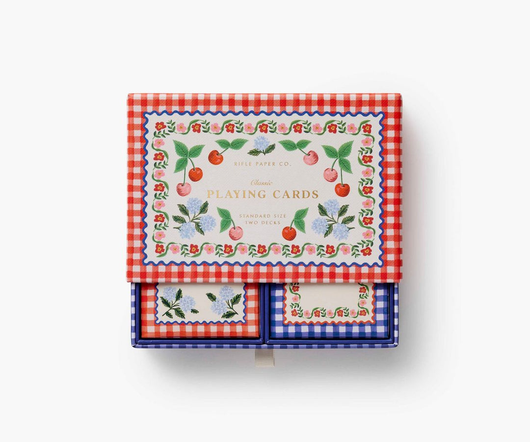 Playing cards with floral and cherry design on a red and white checkered box
