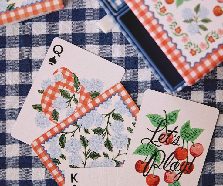Playing cards with decorative designs on a checkered tablecloth
