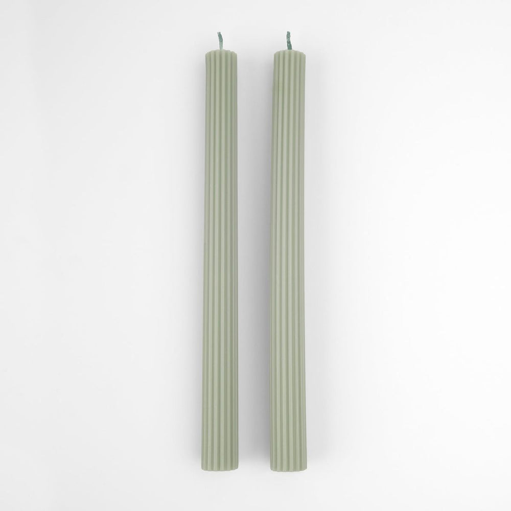 Two green candles on a white background