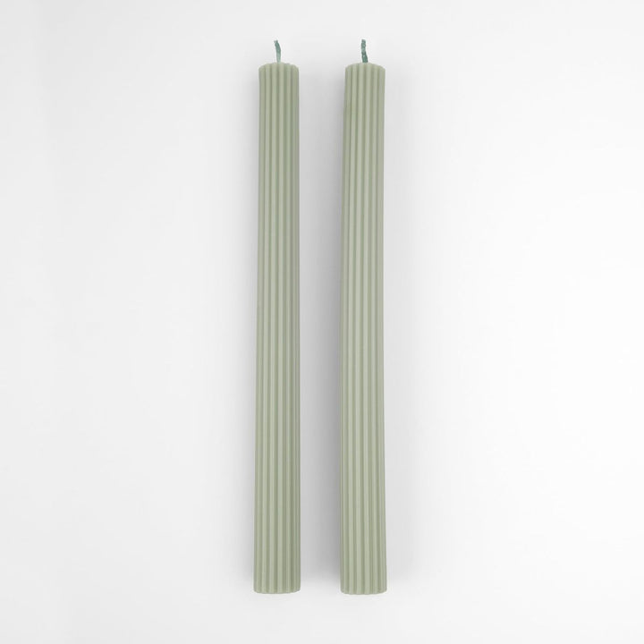 Two green candles on a white background