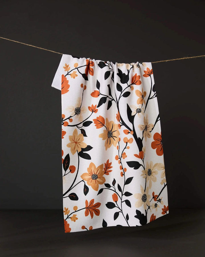 Floral patterned towel hanging on a line against a dark background