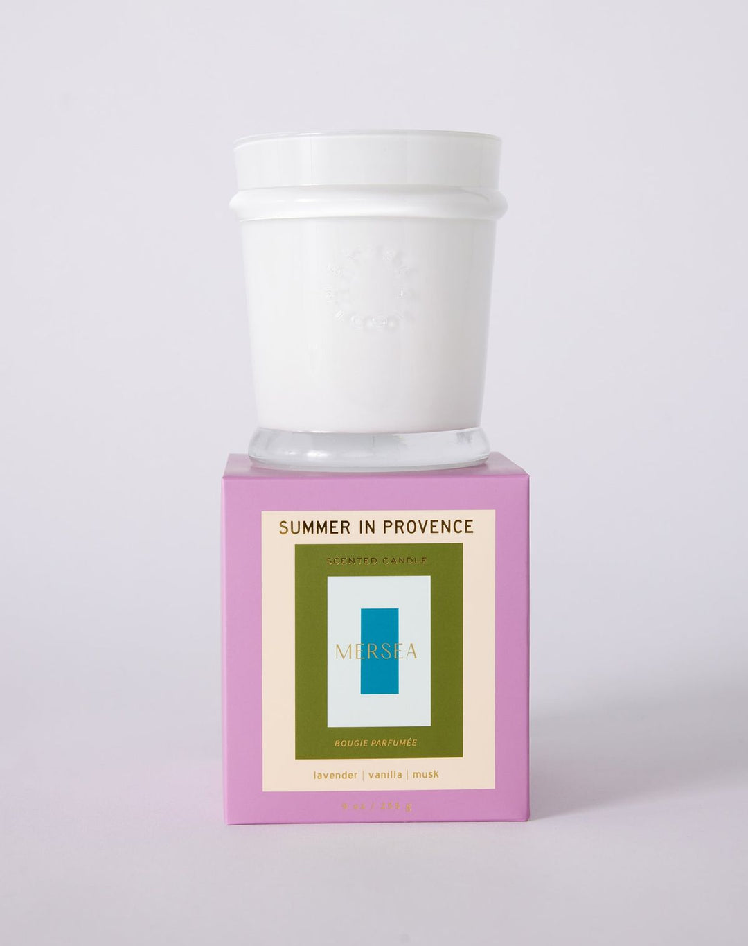 Candle with a white lid on a pink base featuring 'Mushie' branding against a light gray background.