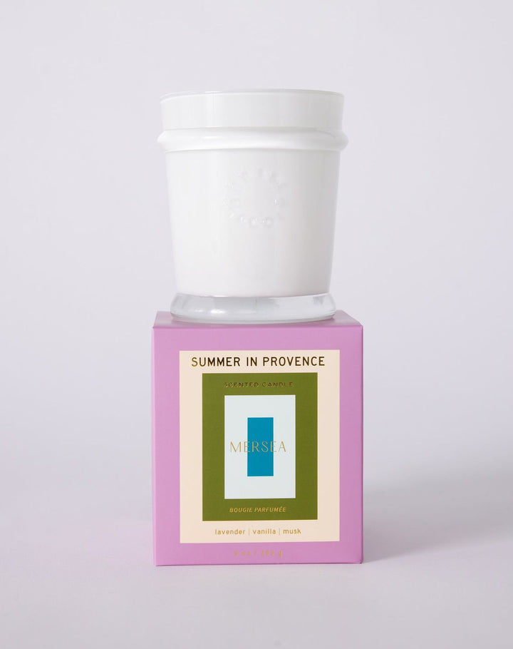 Candle with a white lid on a pink base featuring 'Mushie' branding against a light gray background.