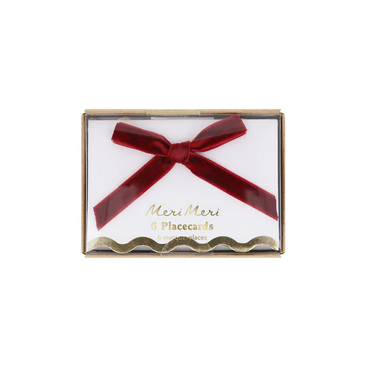 Packaged Meri Meri placecards with a red bow on a white background
