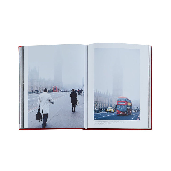 Open book showing two photographs: one of a person walking on a snowy street and another of a red double-decker bus on a road.