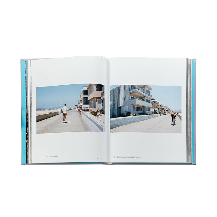 Open book showing two photographs of a coastal street scene with people walking.