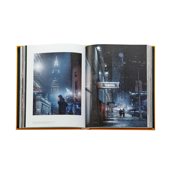 Open book showing a cityscape with a person walking on a snowy street.
