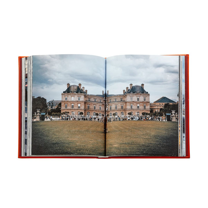 Open book showing a photograph of a large building with a green lawn and people in the background.