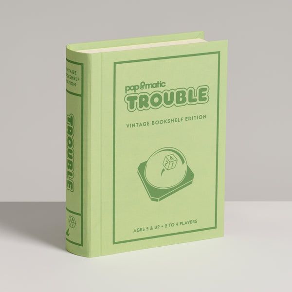 Green book titled 'papématic TROUBLE' on a gray background