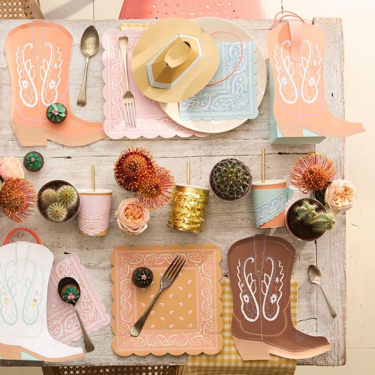 Decorative table setting with cowboy boot and hat theme on a wooden table.