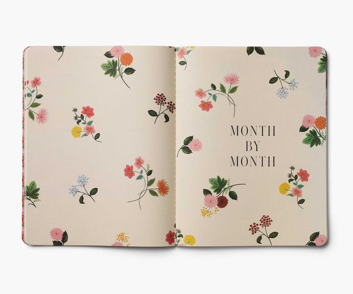 Floral notebook with 'Month by Month' text on a beige background