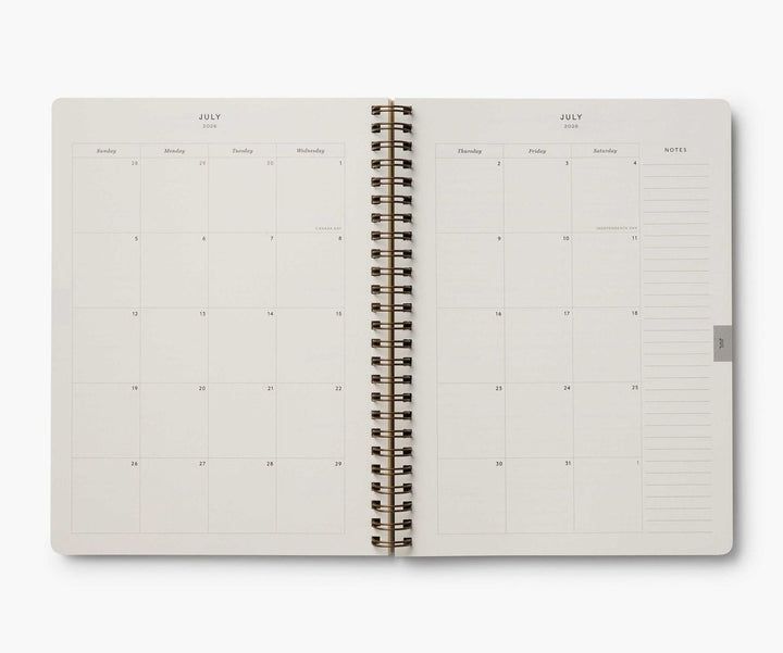 Open spiral-bound planner with July layout on a white background