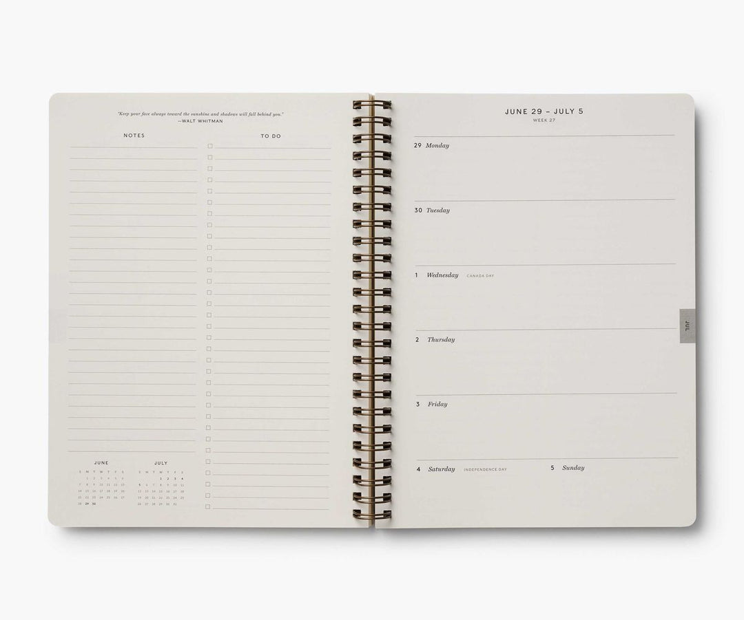Open spiral-bound planner with daily schedule on a white background