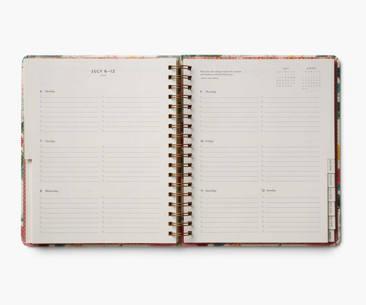 Open spiral-bound planner with weekly layout on a white background