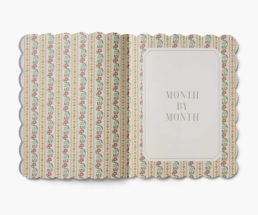 Decorative book with floral pattern and 'Month by Month' text on a white background
