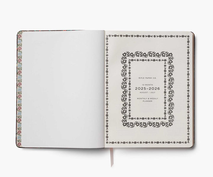 Open planner with decorative cover and brand name on a white background