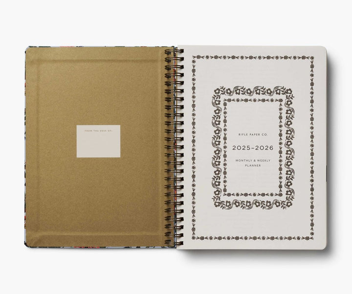 Spiral-bound planner with beige cover and white interior on a white background