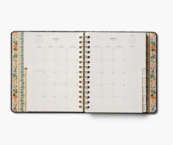 Spiral-bound planner with floral borders on a white background