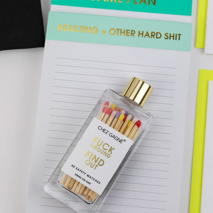 Bottle of matches with colorful matchsticks on a notebook page