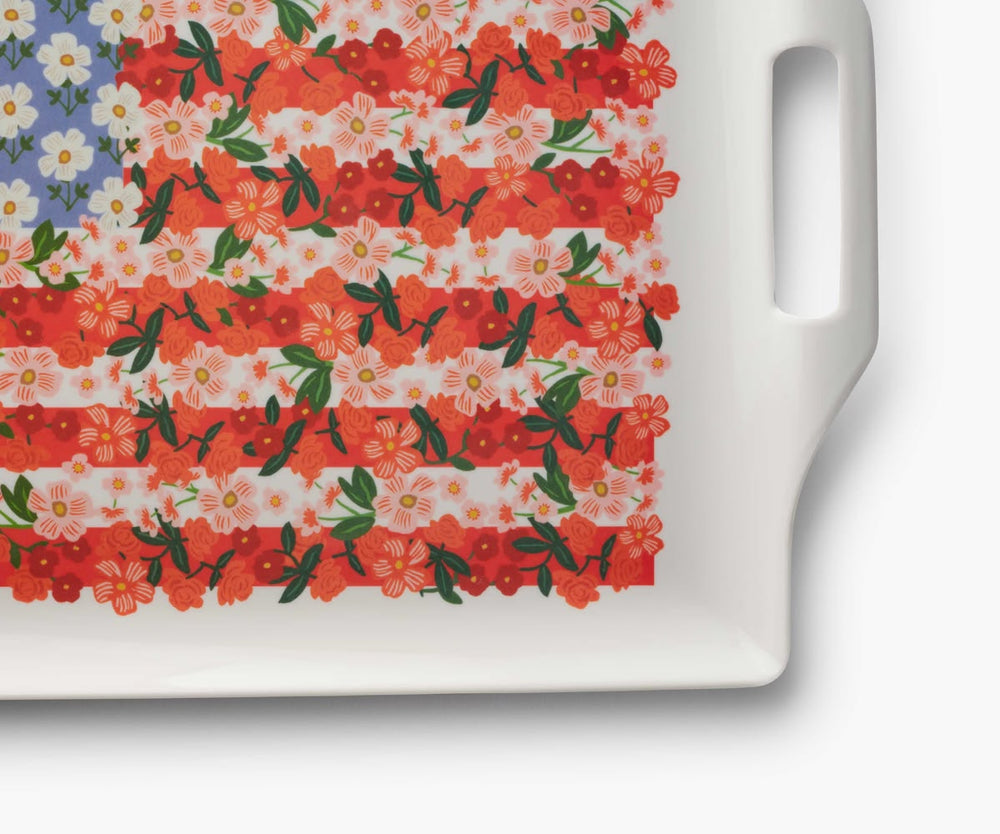 Floral-patterned cutting board with a white handle on a white background