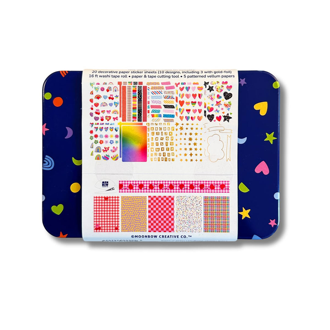 Colorful stationery set with paper stickers, tape roll, and cutting tool in a tin box.