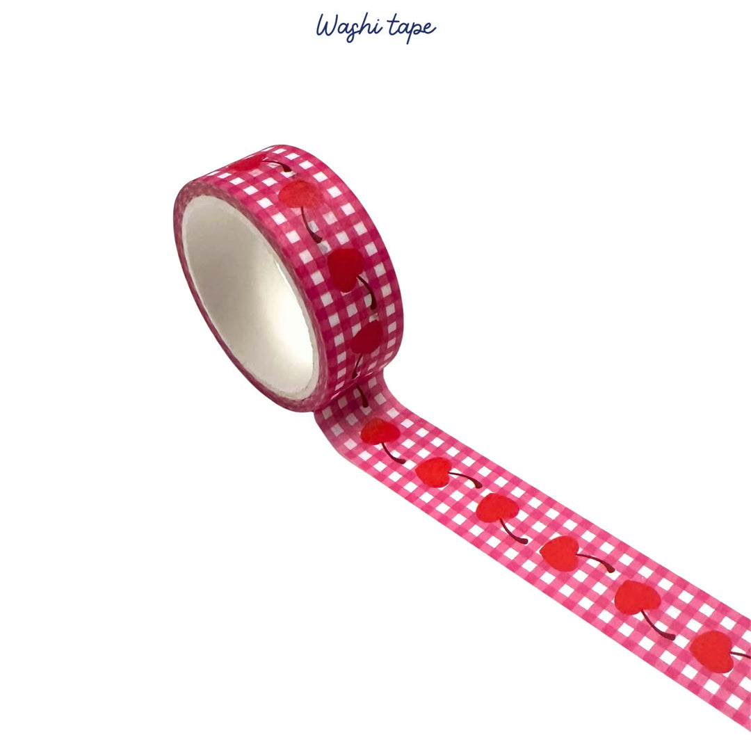 Roll of red and white checkered washi tape with cherry design on a white background