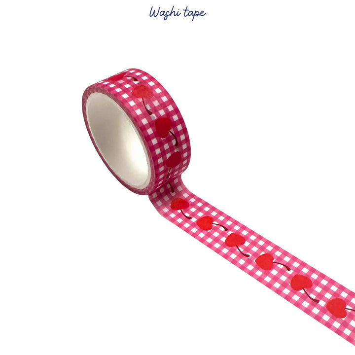 Roll of red and white checkered washi tape with cherry design on a white background