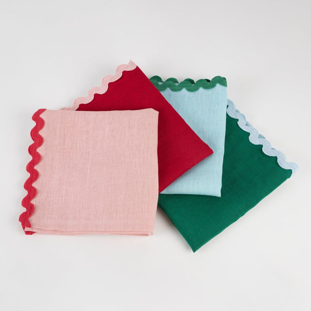 Four colorful fabric squares with scalloped edges on a white background