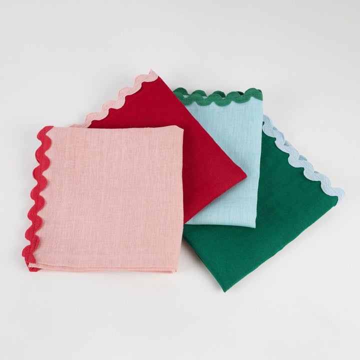 Four colorful fabric squares with scalloped edges on a white background
