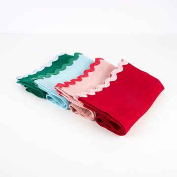 Four folded fabric swatches in green, blue, pink, and red on a white background