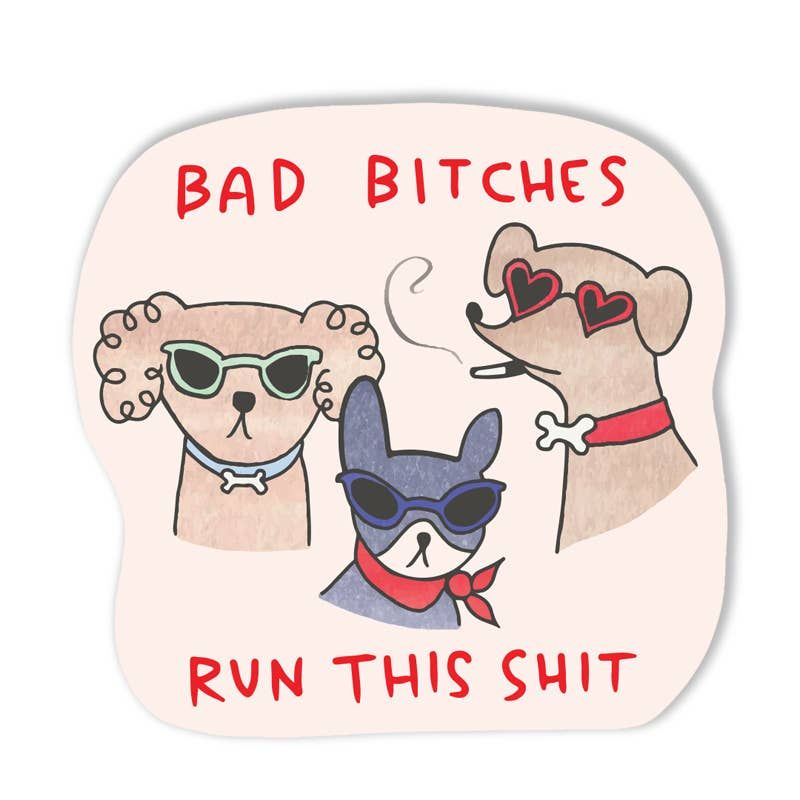 Sticker with cartoon dogs and text 'BAD BITCHES RUN THIS SHIT' on a light pink background