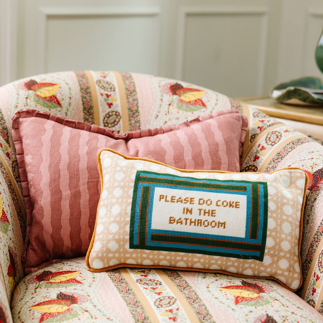 Decorative pillow with text on a patterned sofa