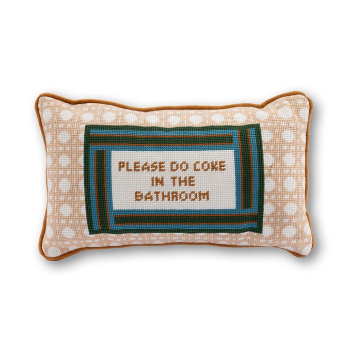 Decorative pillow with text 'Please do coke in the bathroom' on a white background