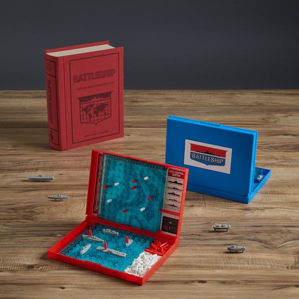 Battleship game set with red and blue boards on a wooden surface