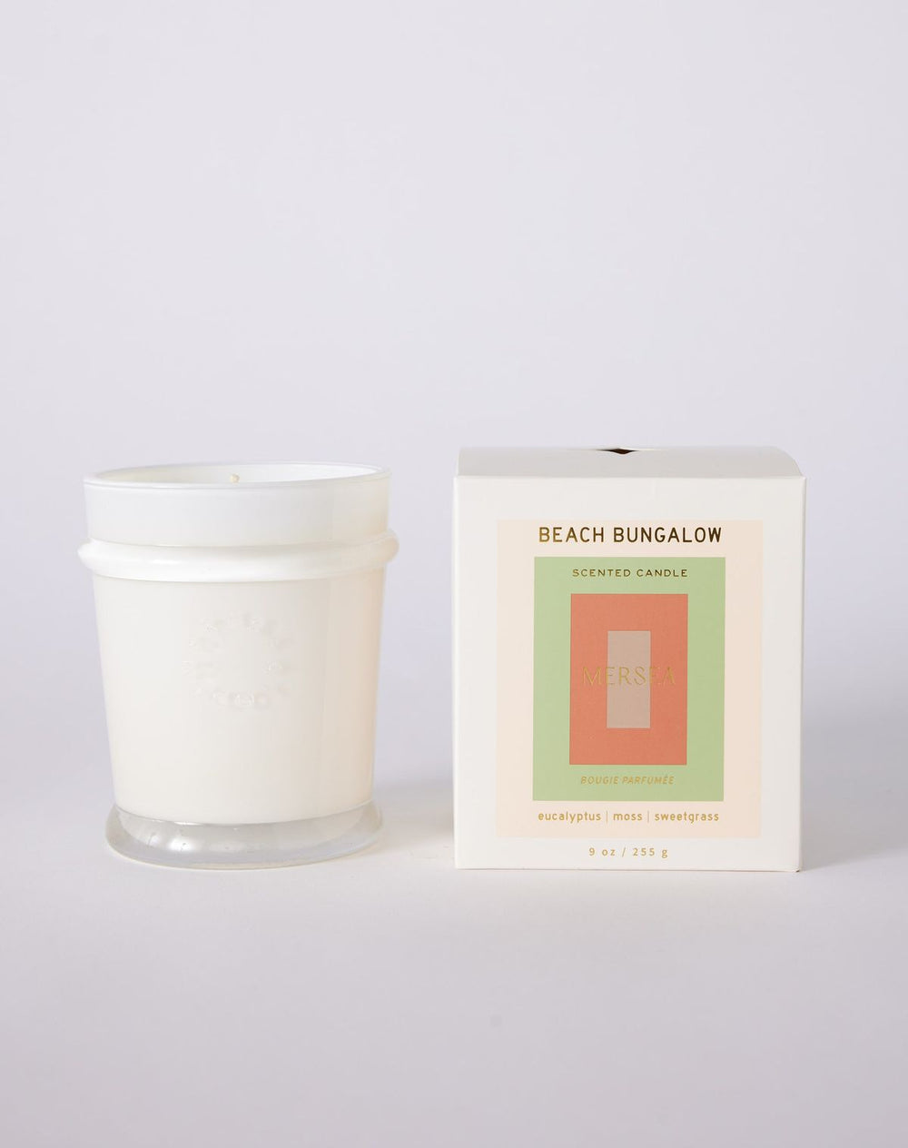 White candle with packaging labeled 'Beach Bungalow' on a light gray background