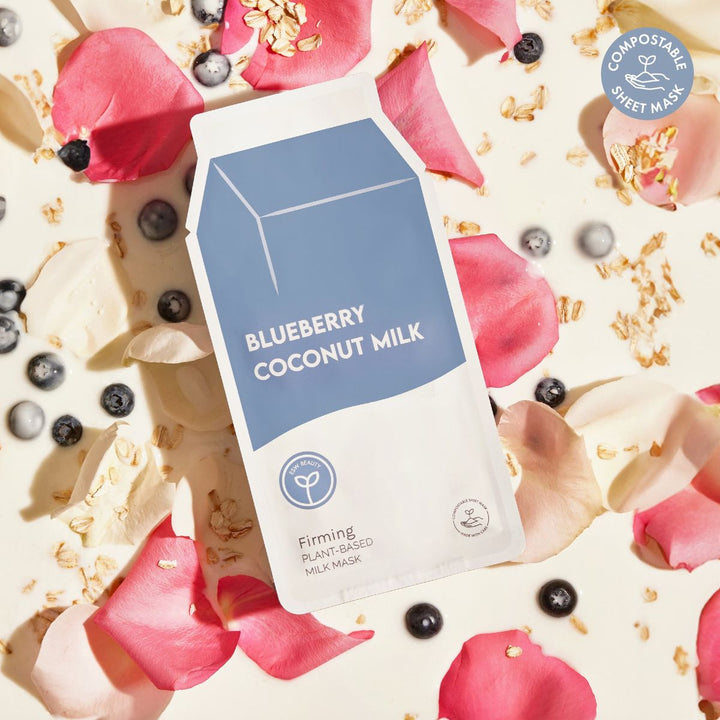 Blueberry Coconut Milk plant-based milk mask packaging on a background with pink petals and blueberries.
