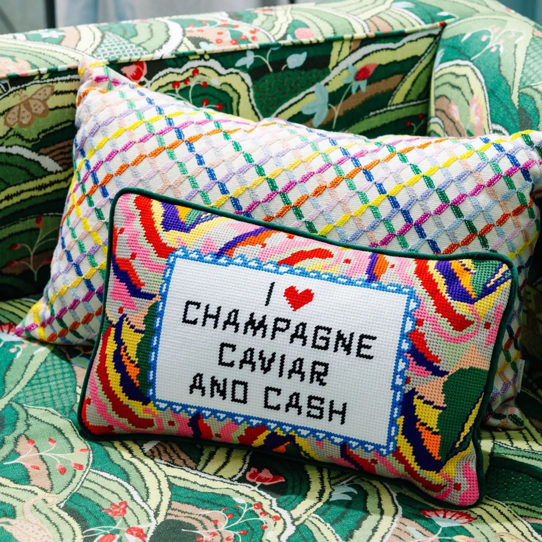 Colorful embroidered pillow with text on a patterned couch
