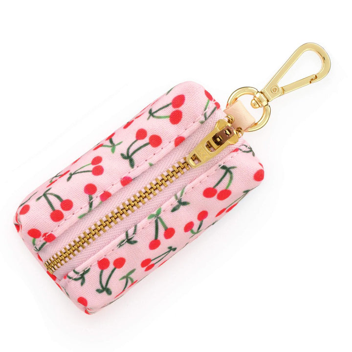 Pink keychain pouch with cherry pattern and gold zipper on a white background