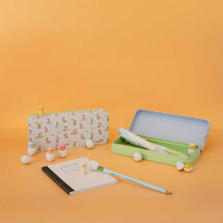 Stationery set with a notebook, pen, and small items on an orange background