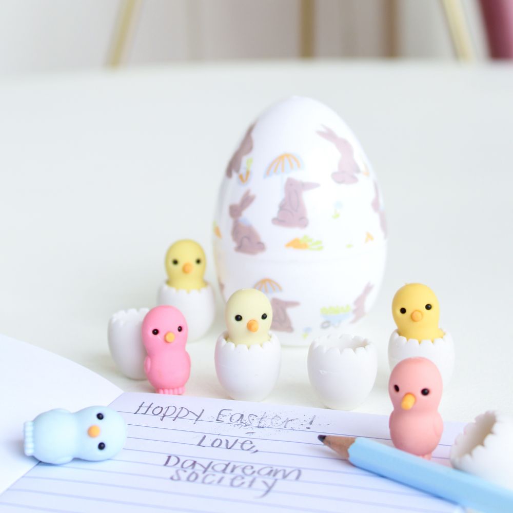 Easter-themed rubber stamps with chicks, eggs, and a pen on a piece of paper.