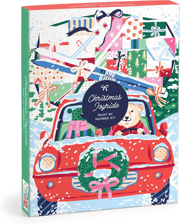 Christmas Joyride Paint by Numbers Kit box featuring a festive illustration of a red car with a green wreath, a teddy bear driving, and a pile of wrapped gifts in the background.