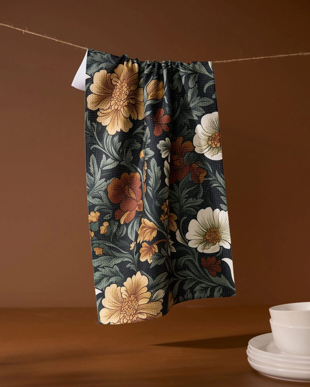 Floral-patterned pants hanging on a line with a brown background